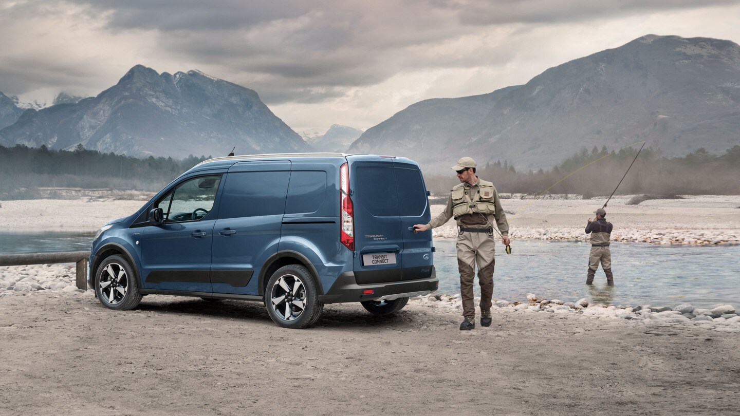 Ford Transit Connect in Blau ¾-Heckansicht parkt an Gewässerufer im Gebirge mit Angler, der Hecktür öffnet