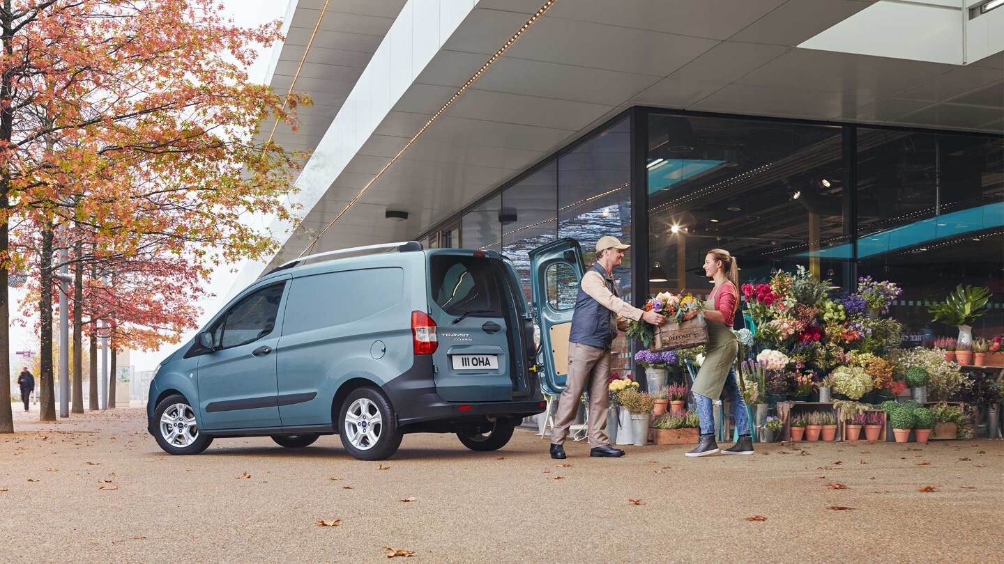 Ford Transit Courier Blau ¾-Seitenansicht geöffnete Hecktür wird vor Blumengeschäft entladen