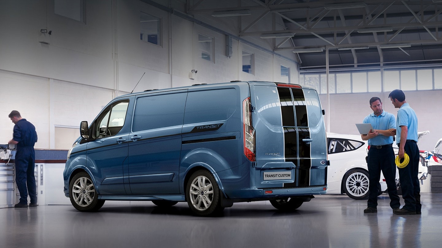 Ford Transit Custom Kastenwagen Sport Blau ¾-Seitenansicht wird in Werkstatthalle geprüft