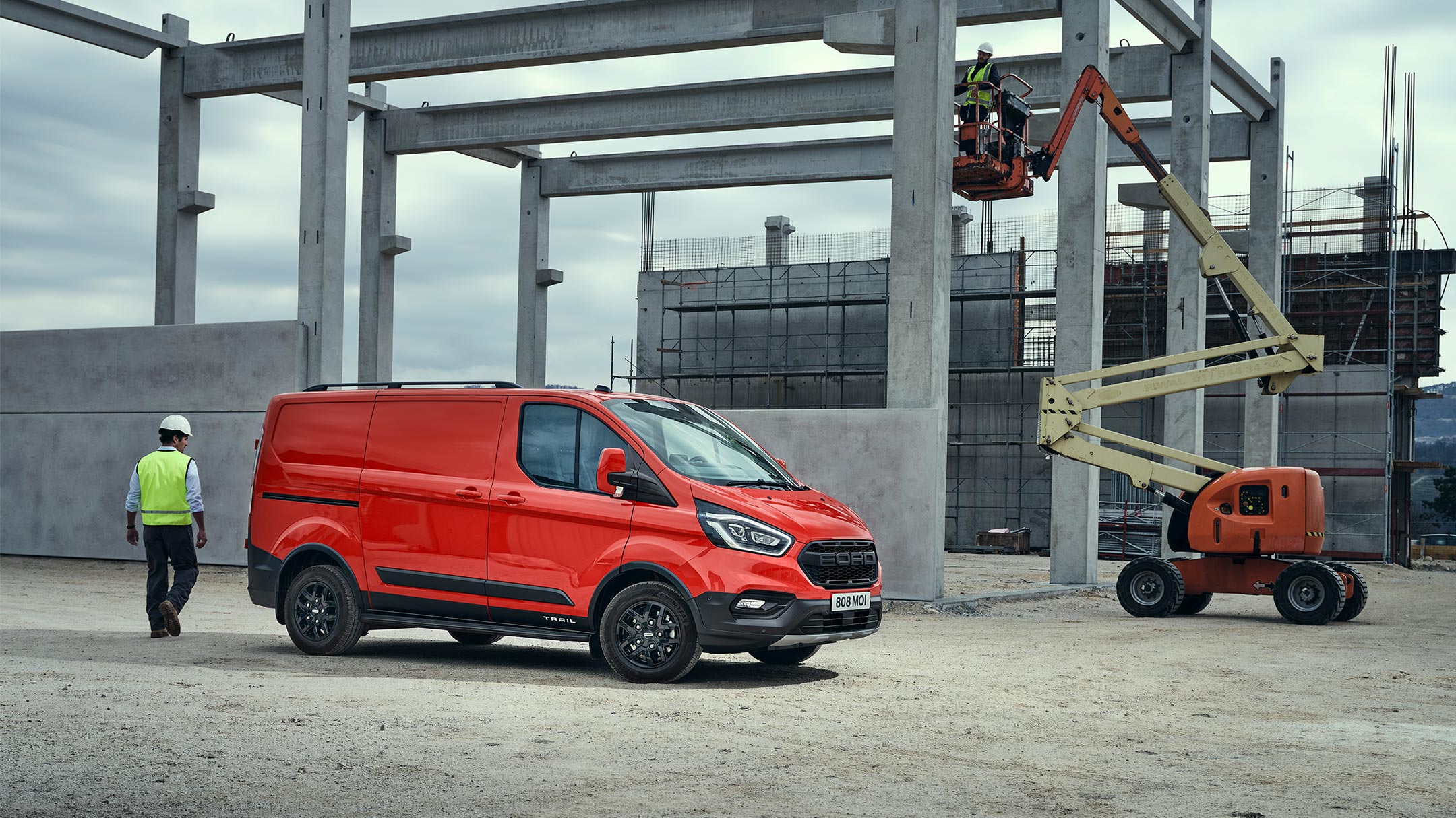 Ford Transit Custom Kastenwagen Trail Rot ¾-Seitenansicht parkt auf Großbaustelle
