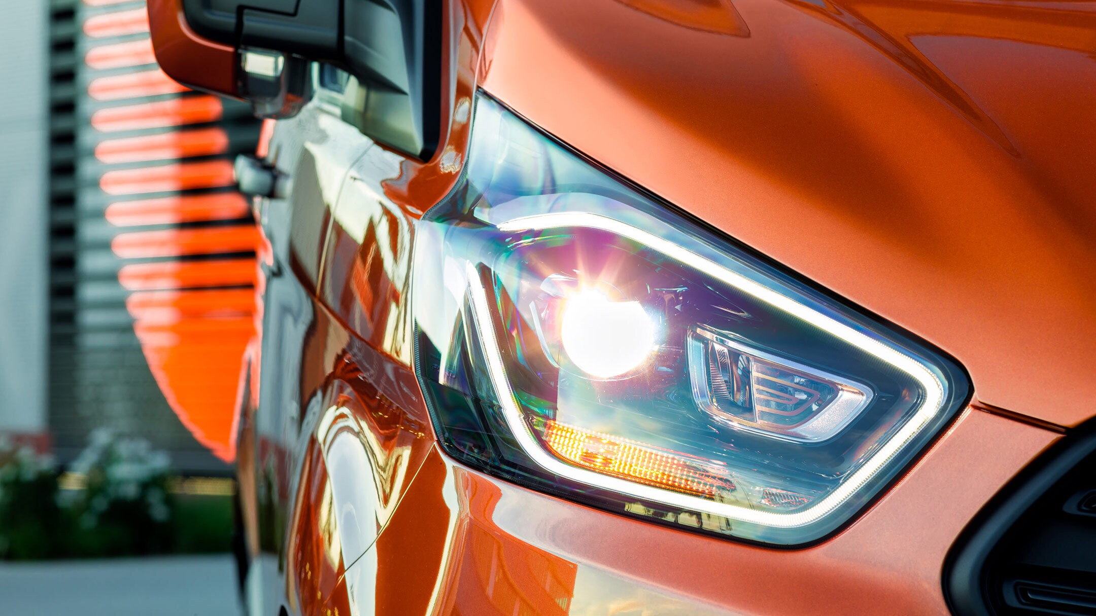 Ford Transit Custom in Orange Ausschnitt LED-Tagfahrlicht im Detail