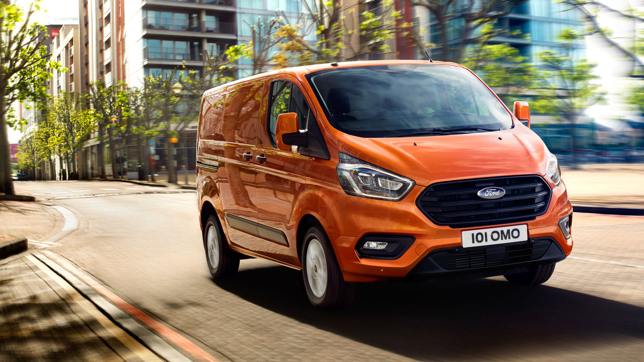 Ford Transit Custom Orange ¾-Frontansicht in Bewegung