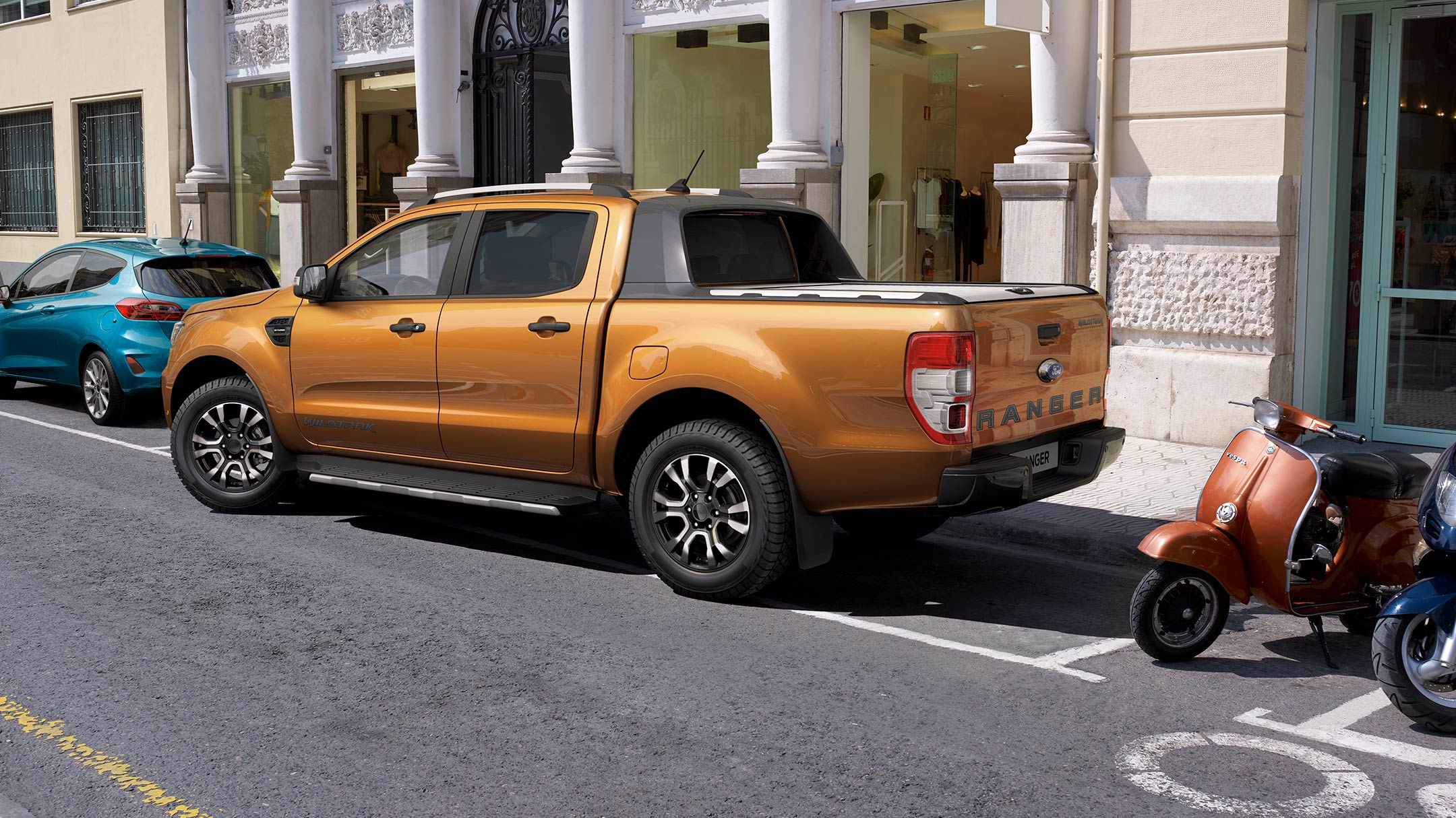 Ford Ranger Orange ¾-Seitenansicht parkt seitlich ein in Parkbucht