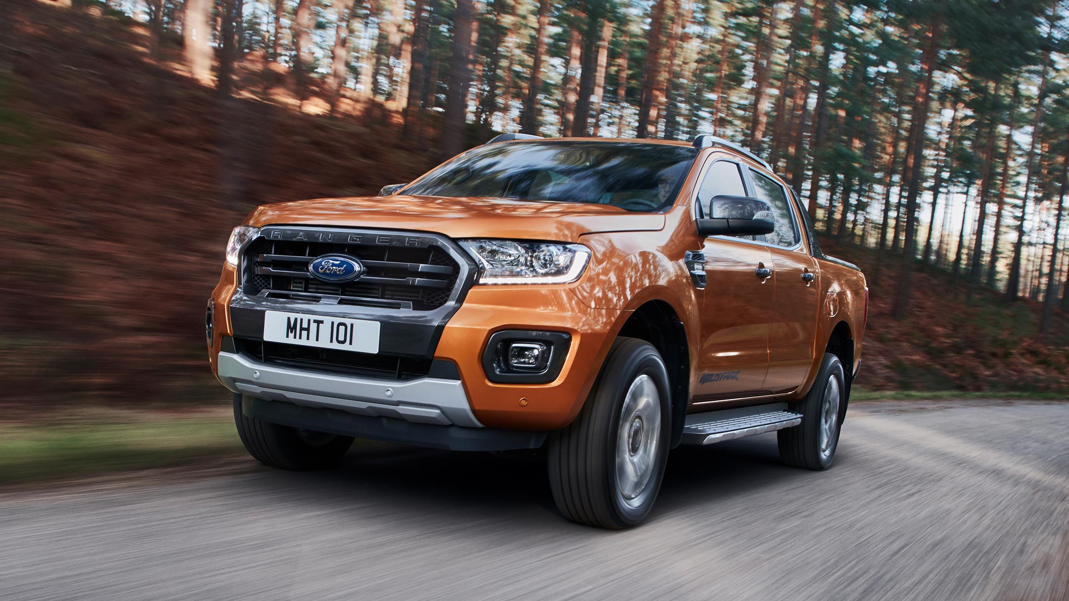 Ford Ranger Orange ¾-Frontansicht in Bewegung auf Forststraße