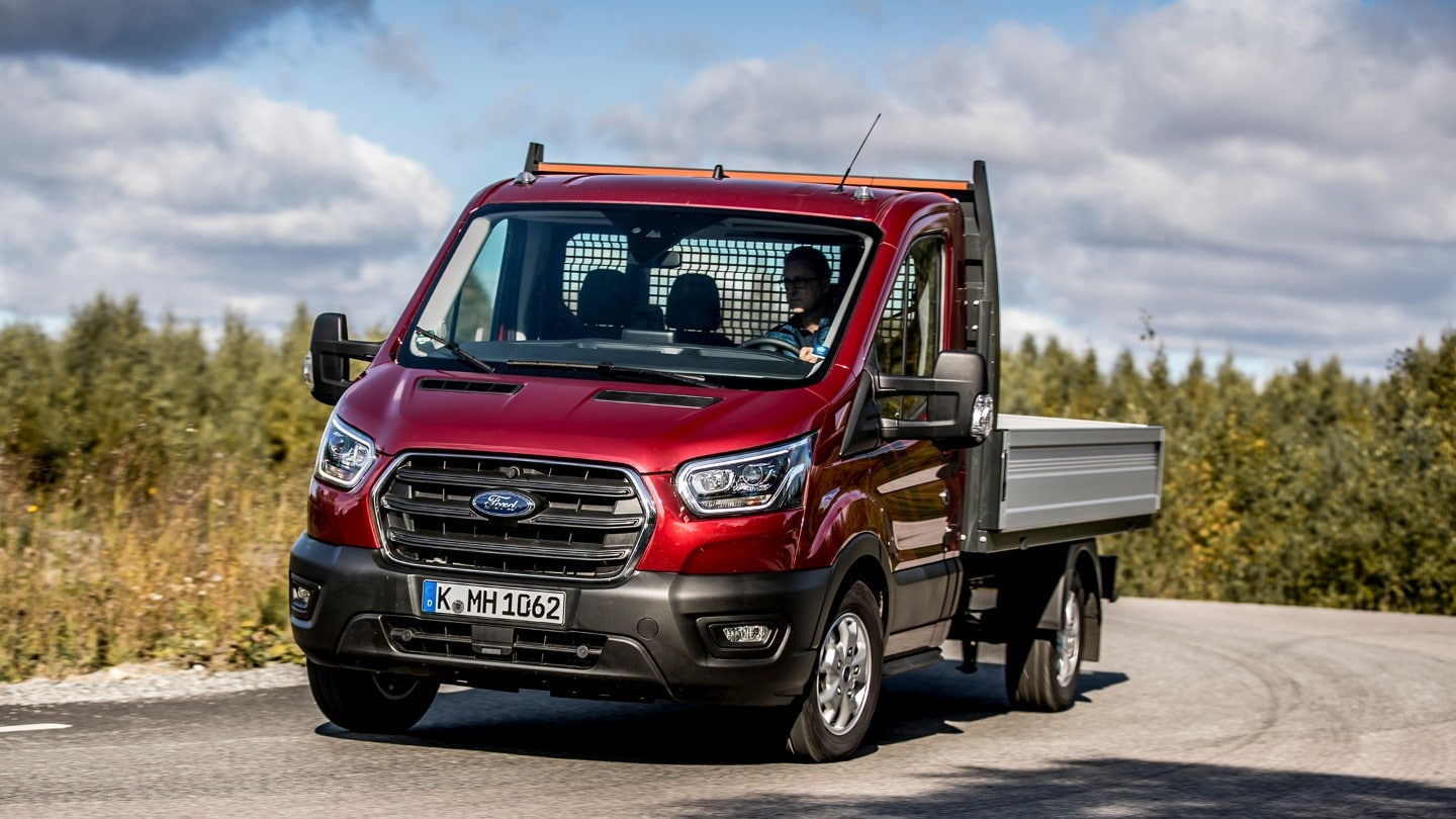 Ford Transit Pritschenwagen Rot, ¾-Frontansicht in Bewegung auf Landstraße