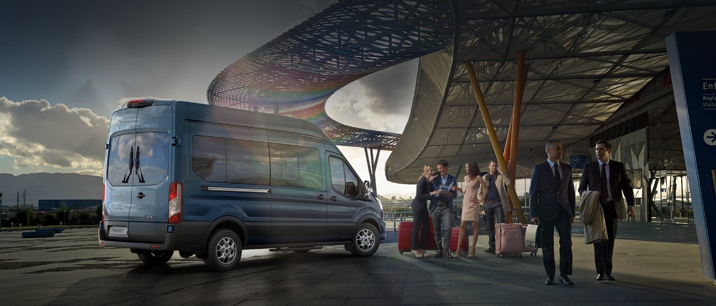 Ford Transit Bus Blau ¾-Seitenansicht mit Reisegruppe parkt an Flughafenterminal