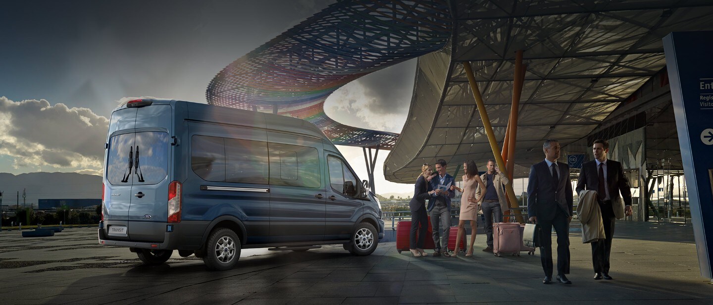 Ford Transit Bus Blau ¾-Seitenansicht mit Reisegruppe parkt an Flughafenterminal