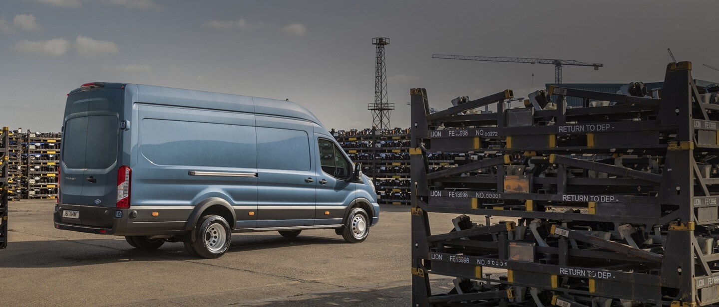 Ford Transit Kastenwagen Blau ¾-Heckansicht in Bewegung auf Straße