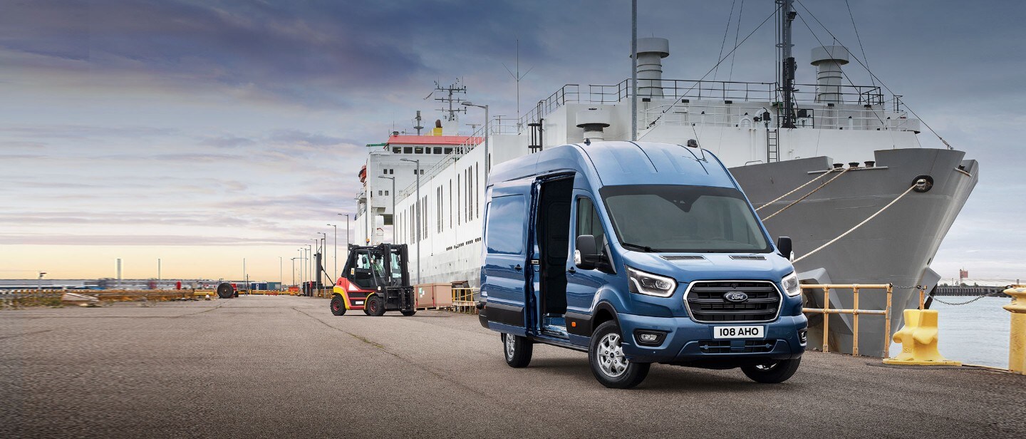 Ford Transit Kastenwagen Blau ¾-Frontansicht parkt vor Schiff in Hafen