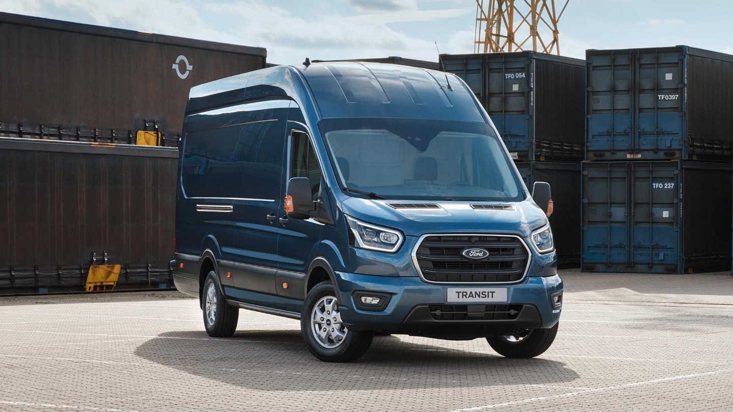 Ford Transit Kastenwagen in Blau ¾-Frontansicht parkt vor Frachtcontainern