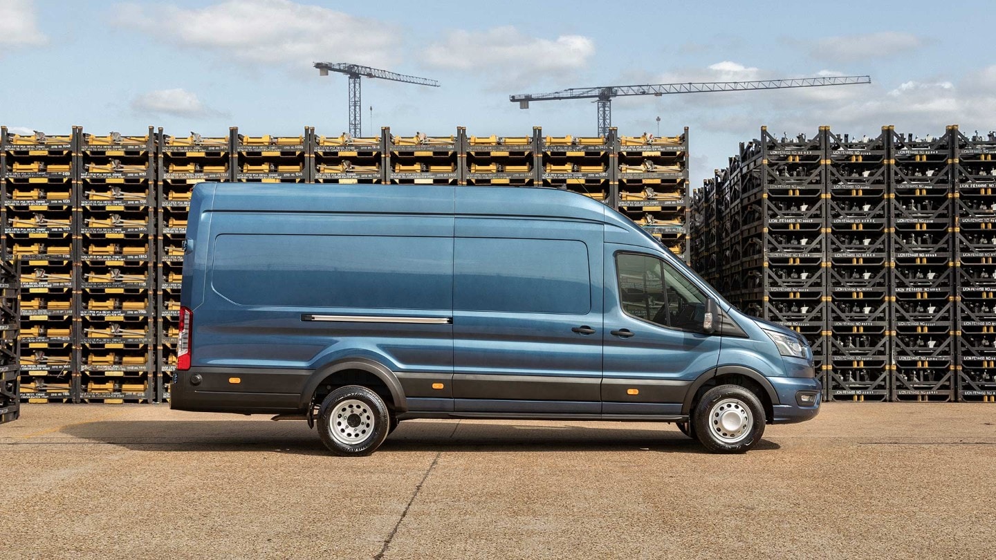 Ford Transit 5 Tonnen Kastenwagen LKW Blau Seitenansicht parkt auf Betriebsgelände vor Palettenstapeln