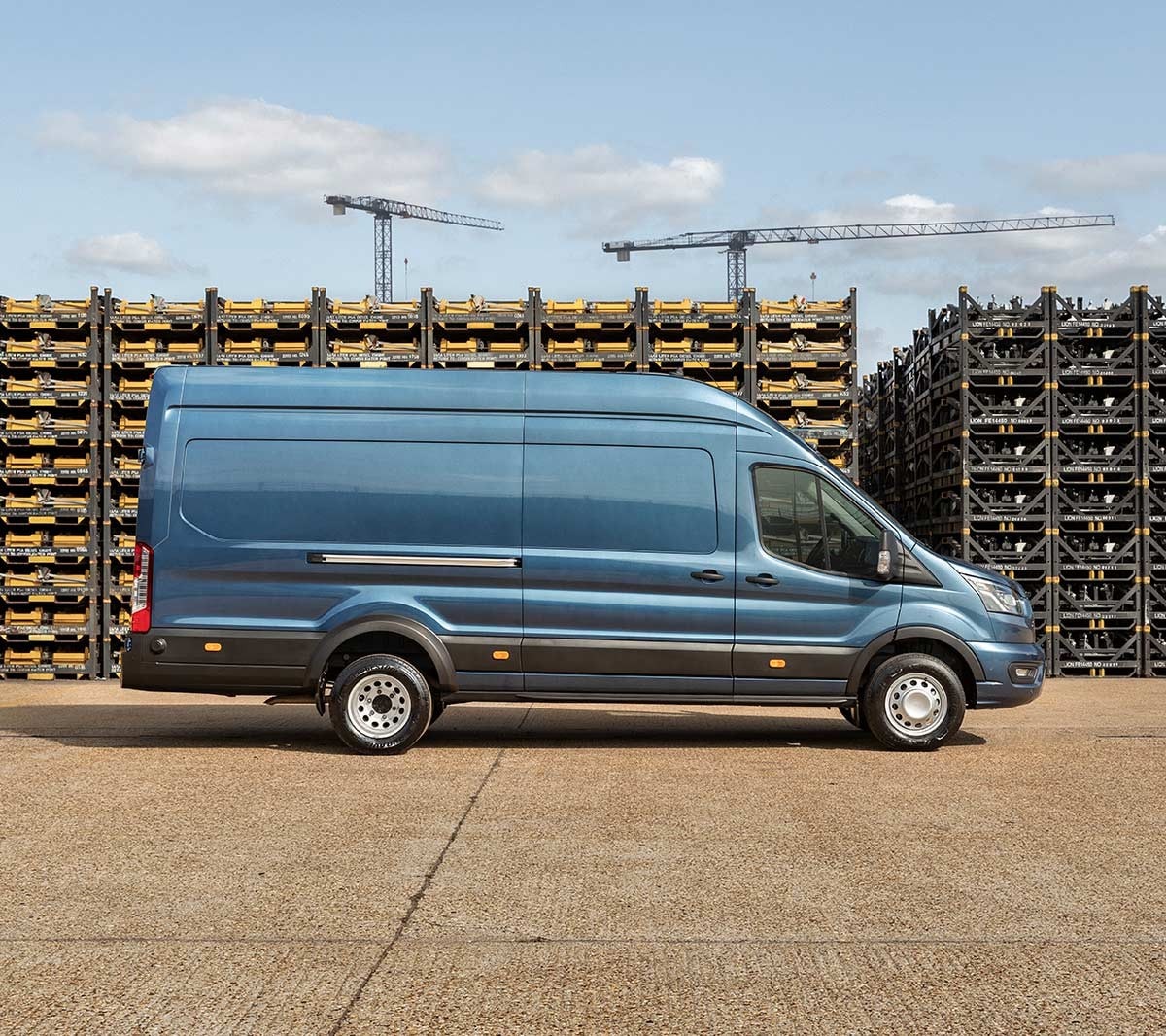 Ford Transit 5 Tonnen Kastenwagen LKW Blau Seitenansicht parkt auf Betriebsgelände vor Palettenstapeln