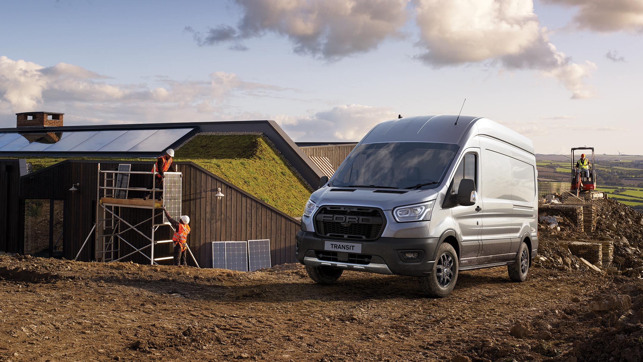 Ford Transit Kastenwagen Trail Silber ¾-Frontansicht parkt auf Baustelle in ländlicher Region