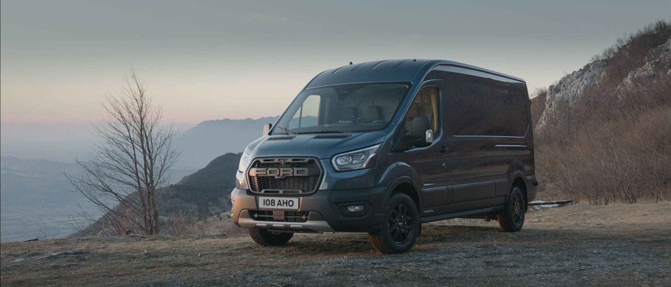 Ford Transit Kastenwagen Trail Blau ¾-Frontansicht in Bewegung auf Gebirgsstraße