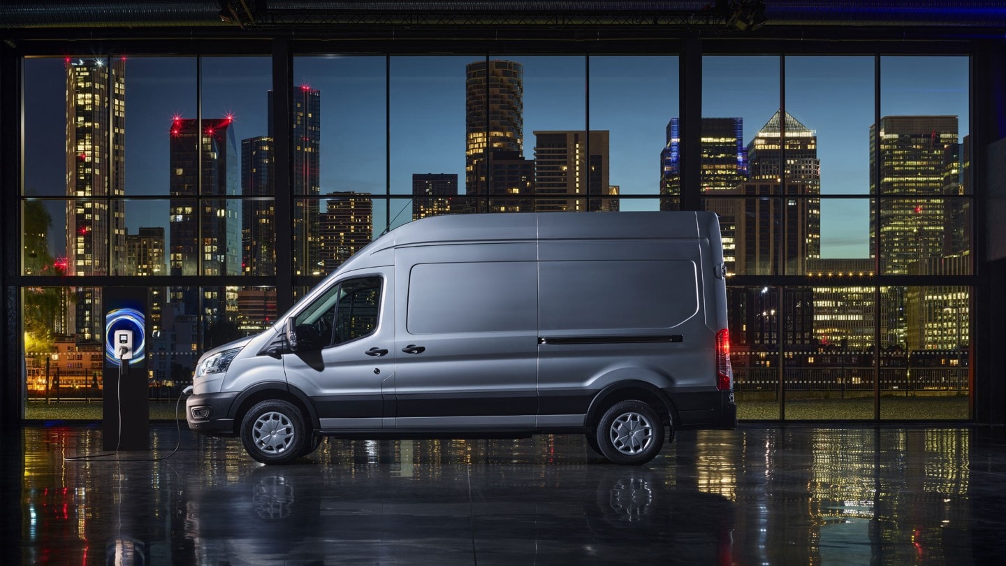 Ford E-Transit in Silber Seitenansicht beim Aufladen