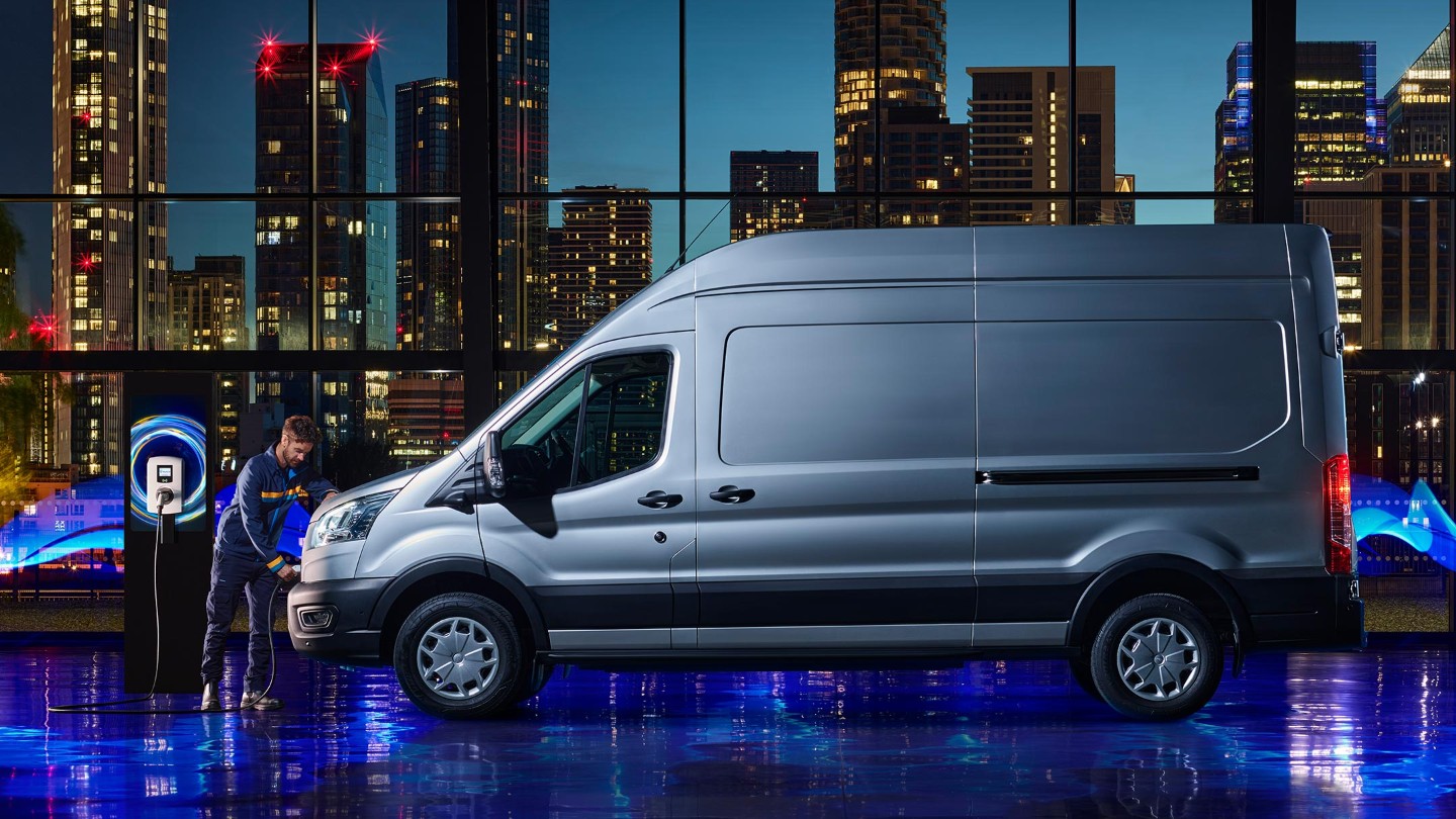 Ford E-Transit silber Seitenansicht parkt in Ausstellungshalle und wird aufgeladen