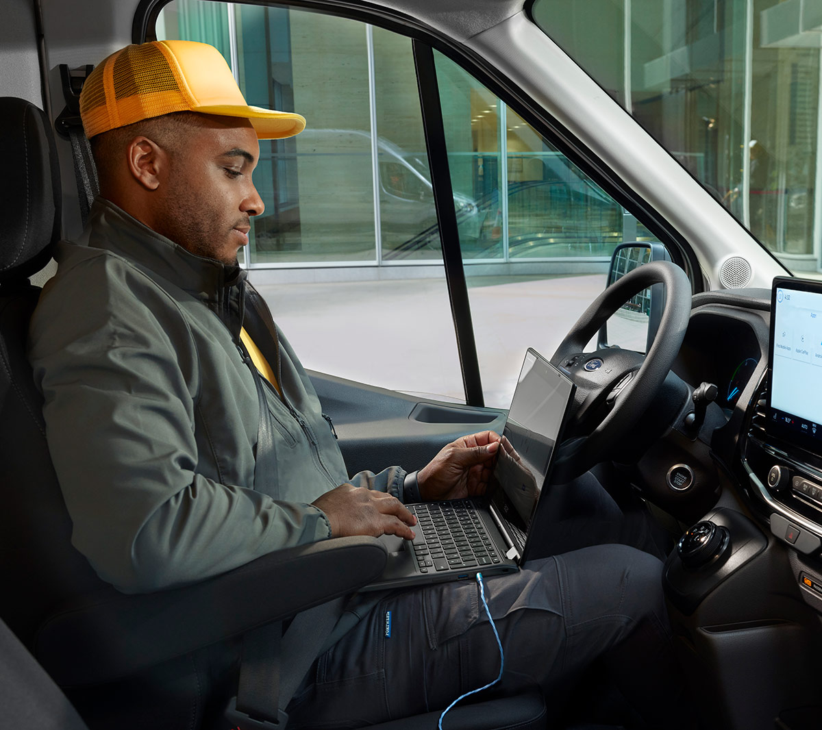 Arbeiter Laptop im elektrischer Ford E-Transit Fahrgestell Pritsche Innenraum