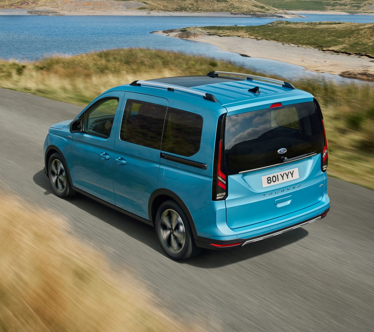 Ford Tourneo Connect in Hellblau ¾-Heckansicht fährt auf Landstraße