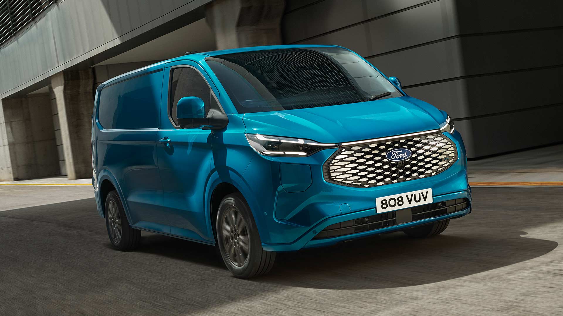 Blauer Ford E-Transit Custom Elektro-Transporter faehrt.  