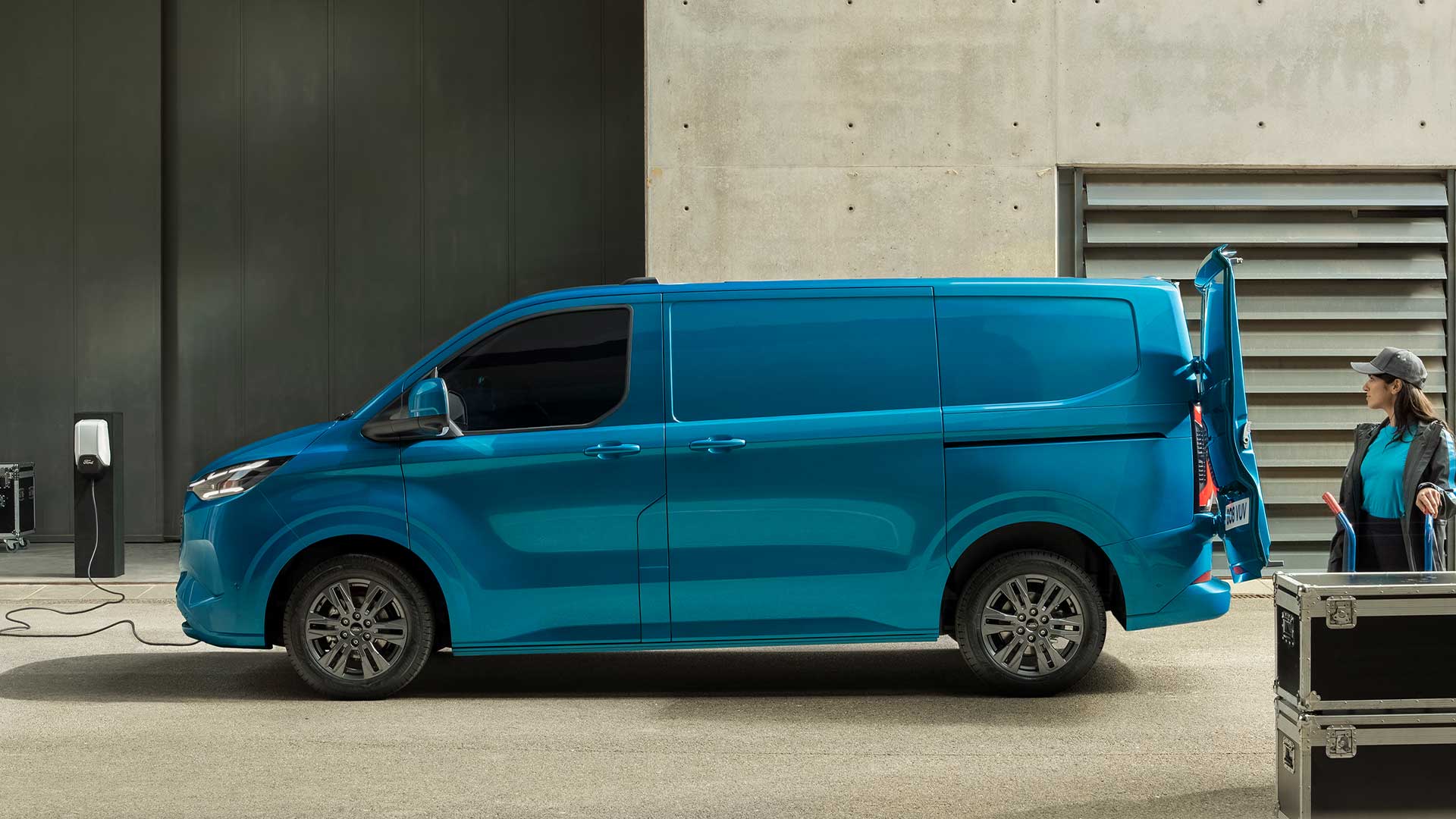 Blauer Ford E-Transit Custom Elektro-Transporter beim Laden.