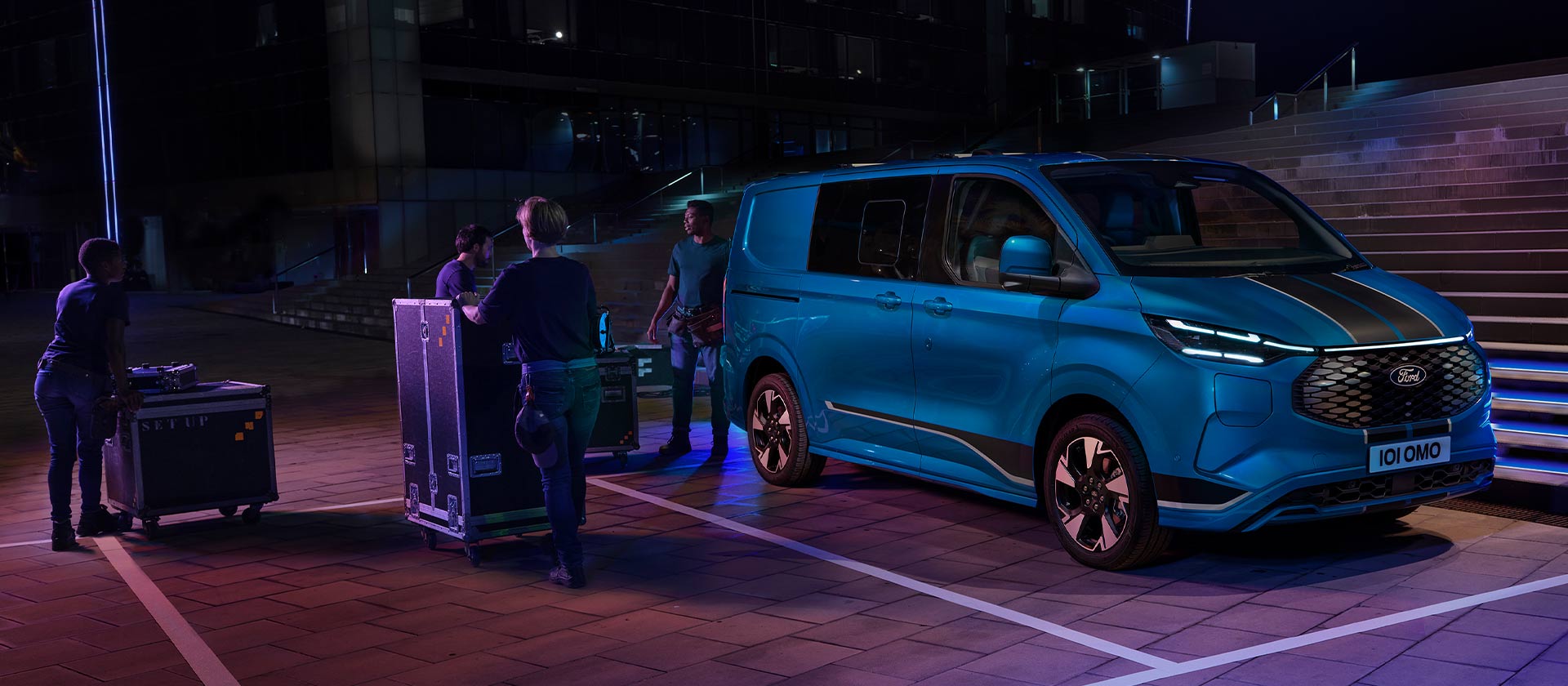 Blauer Ford E-Transit Custom Doppelkabine bei Nacht.