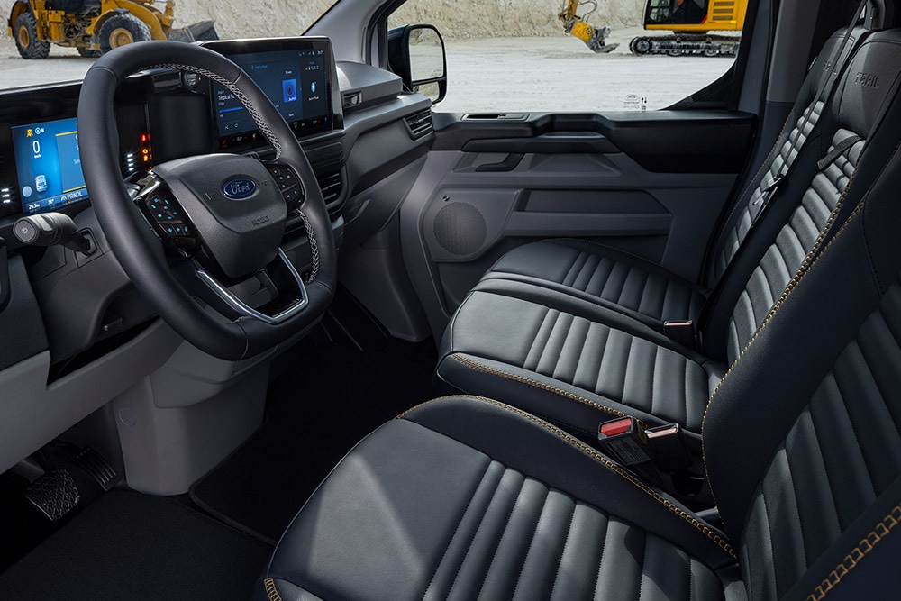 Innenansicht eines Ford E-Transit Custom Sport Elektro-Transporters mit schwarzen und goldenen Sitzen.  