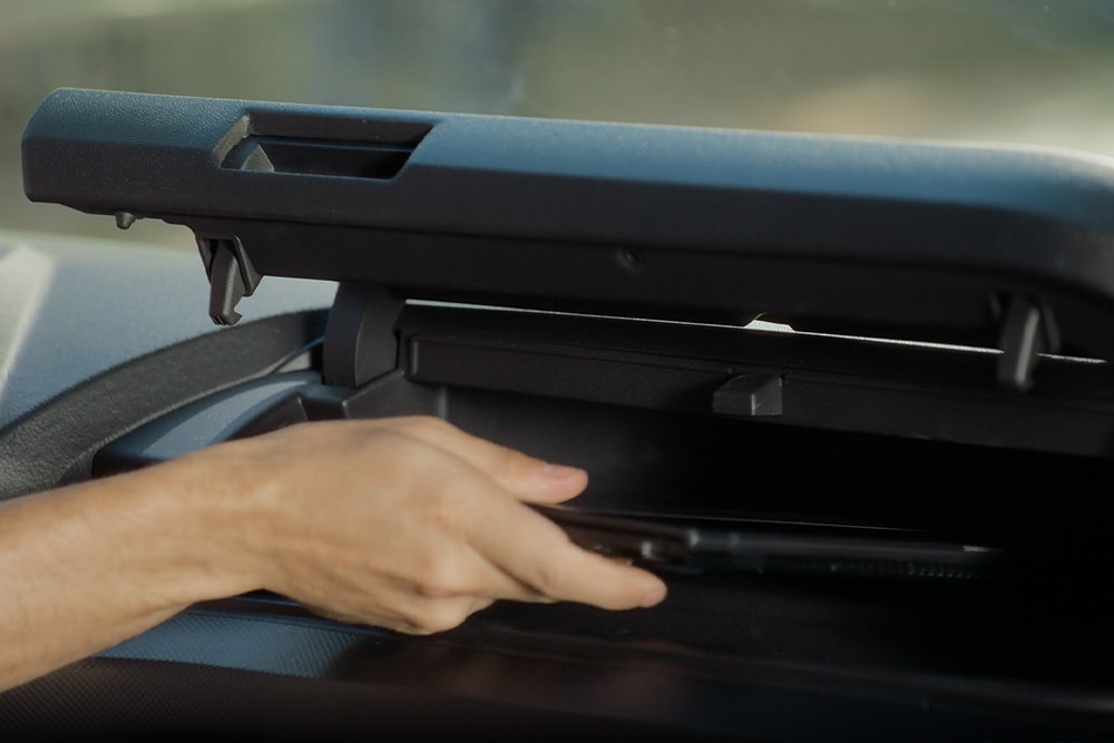 Hand oeffnet ein Staufach im Ford E-Transit Custom Elektro-Transporter.  