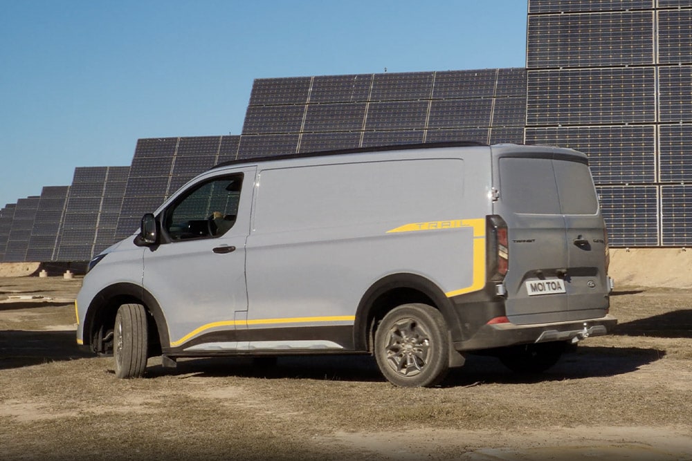Grauer Ford Transit Custom Trail Transporter mit gelben Akzenten.  
