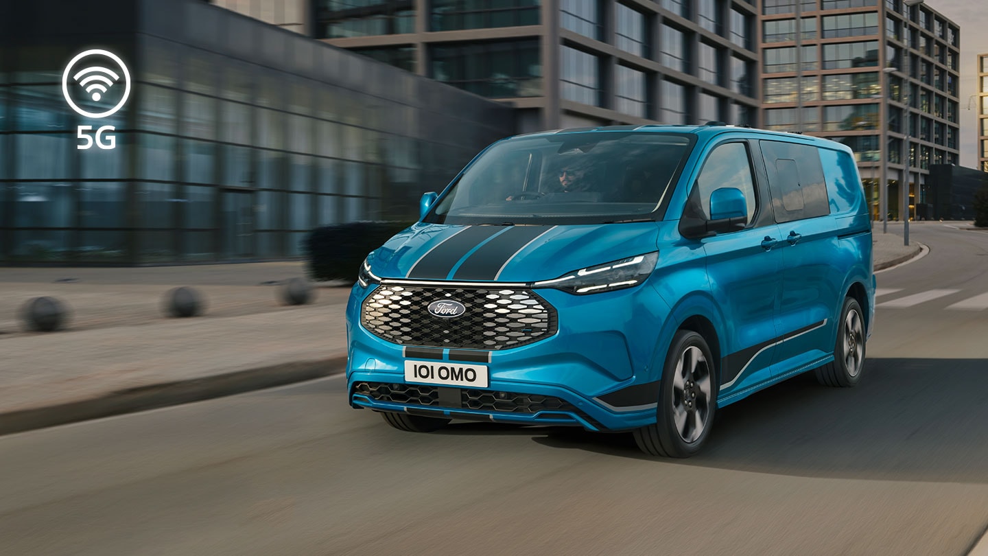 Blauer Ford E-Transit Custom Elektro-Transporter faehrt durch die Stadt.  