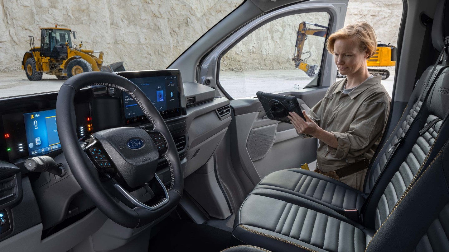 Ford Transit Custom Innenansicht Blick in Fahrerkabine und Angestelle hält Tablet