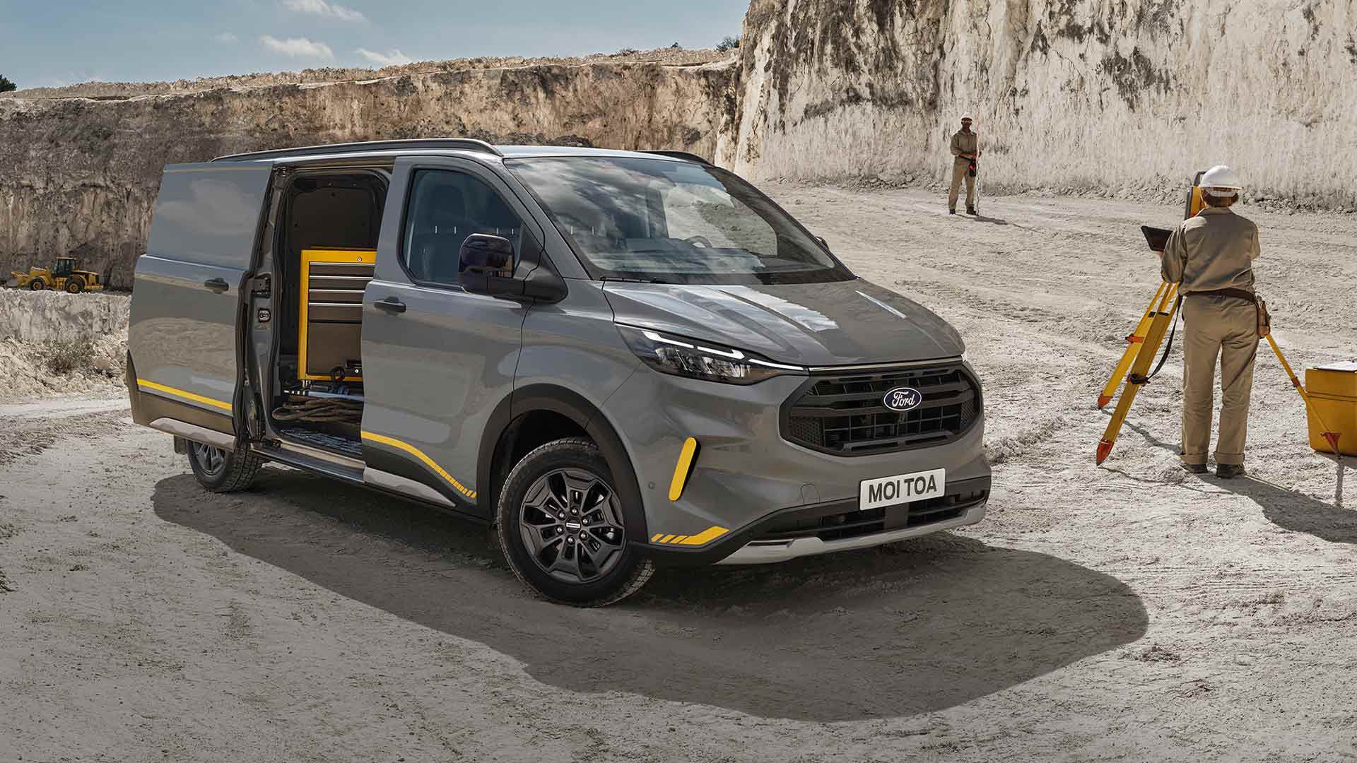 Grauer Ford Transit Custom Trail Van bei einem Steinbruch.