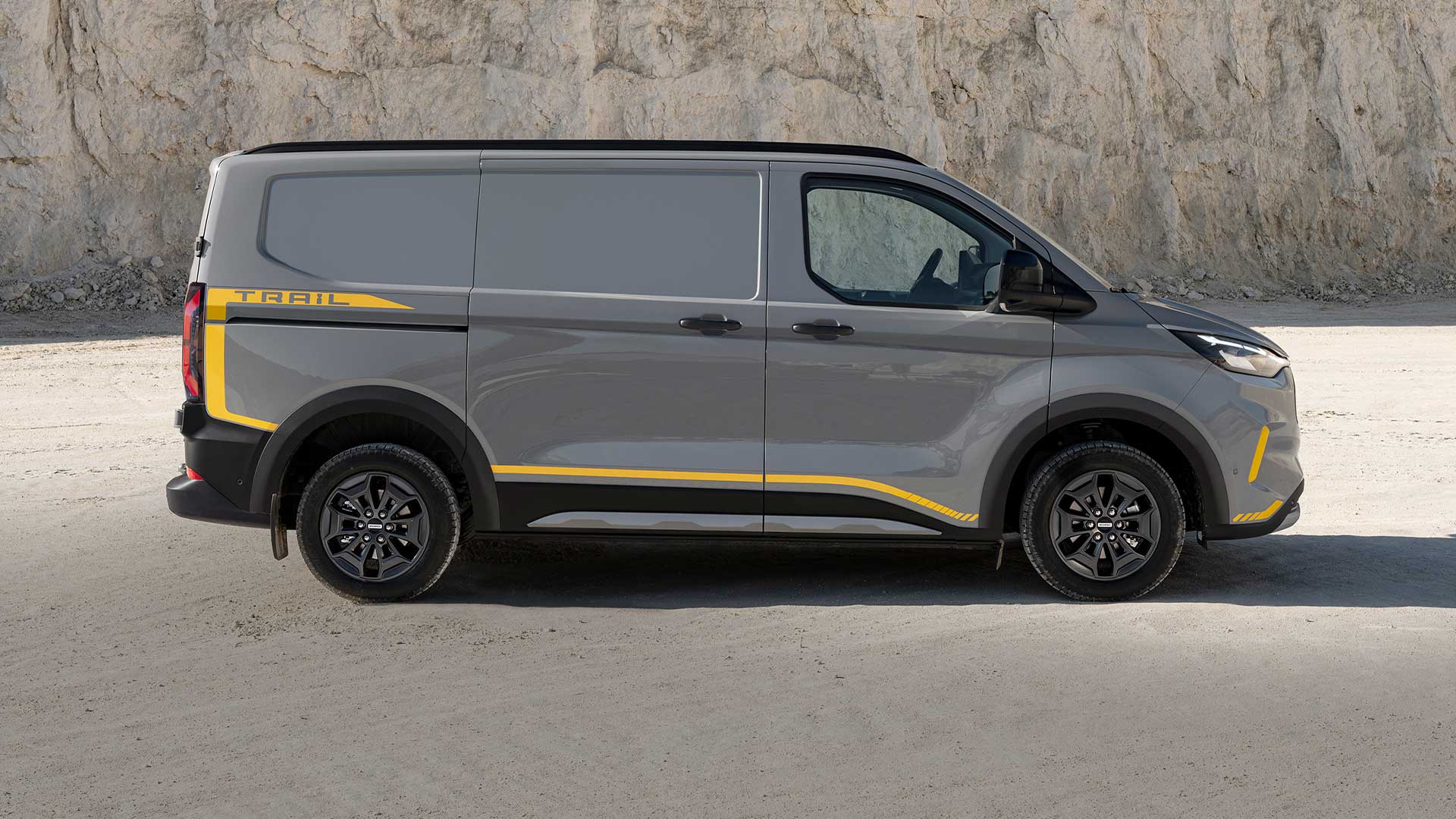 Grauer Ford Transit Custom Trail Transporter mit gelben Akzenten, Seitenansicht