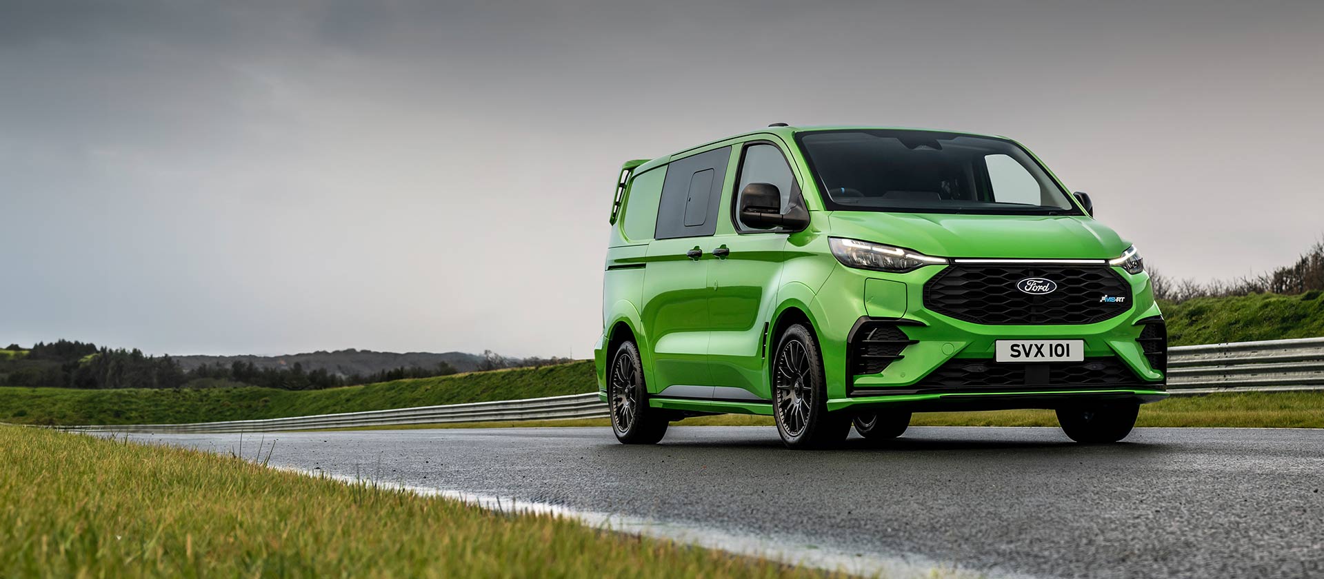 Grüner Ford Transit Custom MS-RT fährt auf der Rennstrecke.
