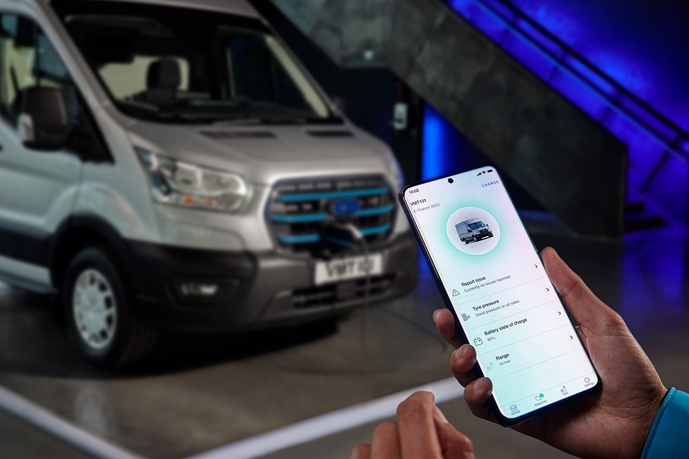 Person hält ein Smartphone, das Fahrzeugdaten aus Ford Pro auf dem Display zeigt