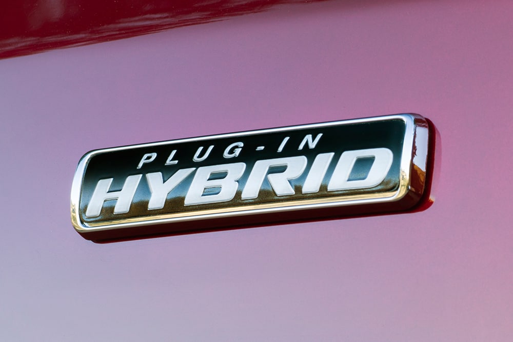 „Plug-in Hybrid“-Emblem an einem roten Ford Transit Custom. 