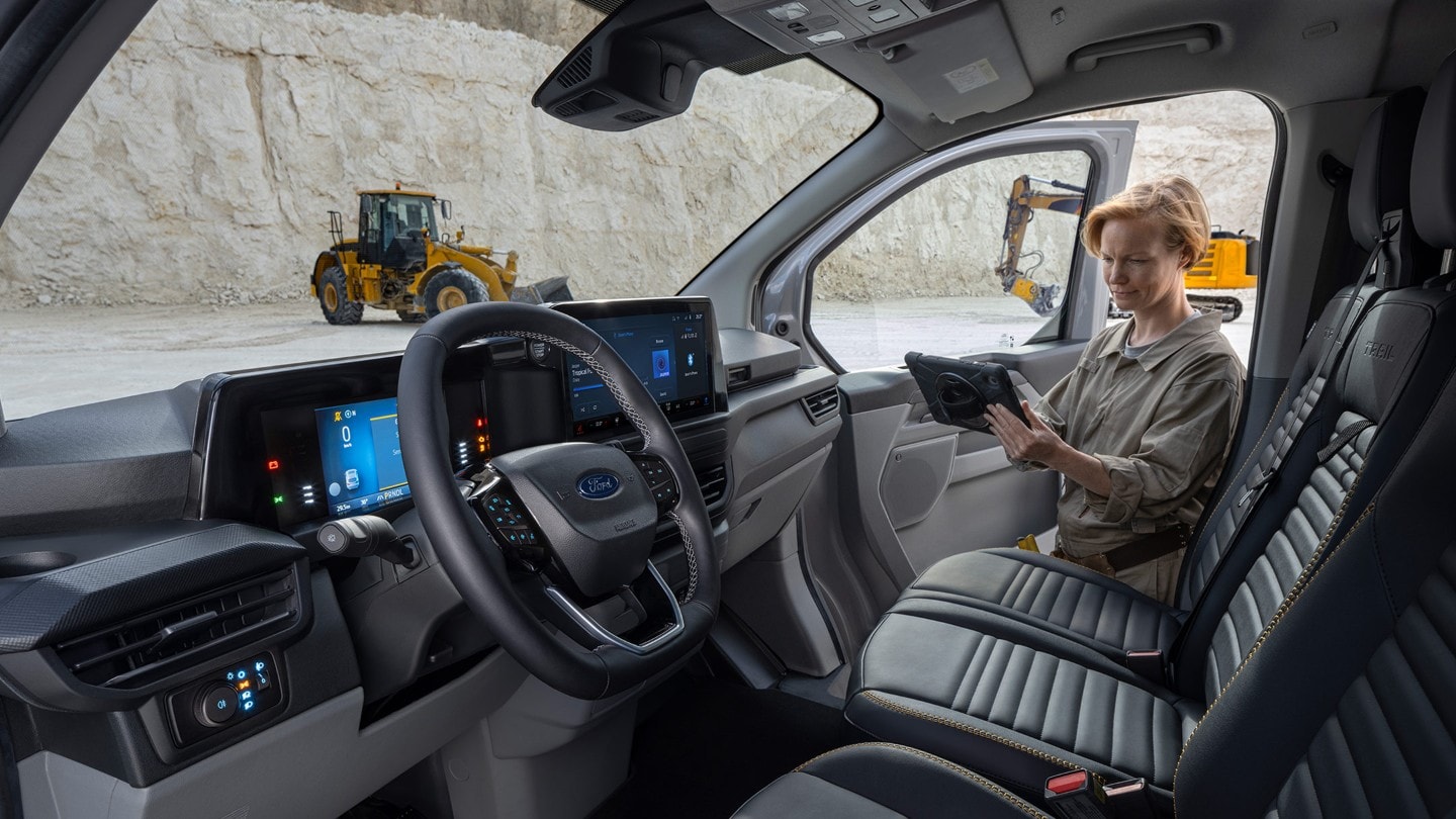 Ford Transit Custom Innenansicht Blick in Fahrerkabine und Angestelle hält Tablet