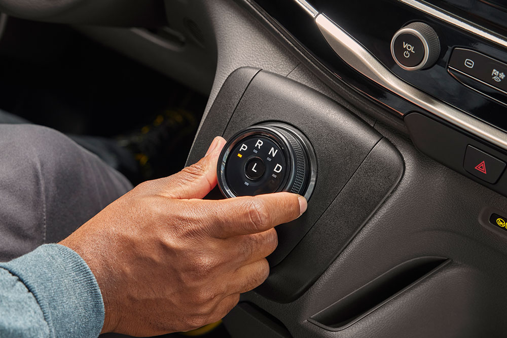 Nahaufnahme einer Hand, die den Gangwahlknopf in einem Ford E-Transit Kastenwagen dreht.