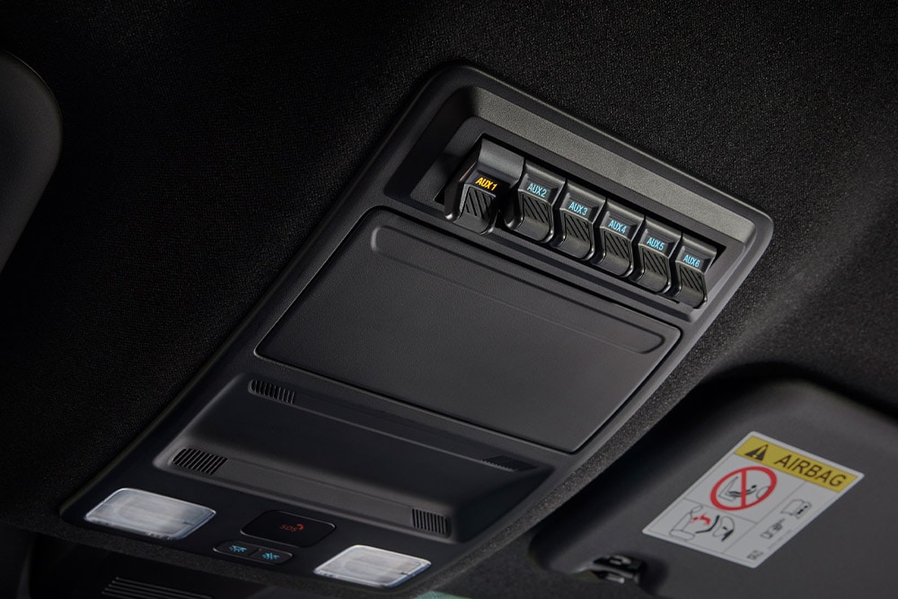 Nahaufnahme von Händen, die Kabel in die Steckdose in der Ladefläche des Ford Ranger stecken.