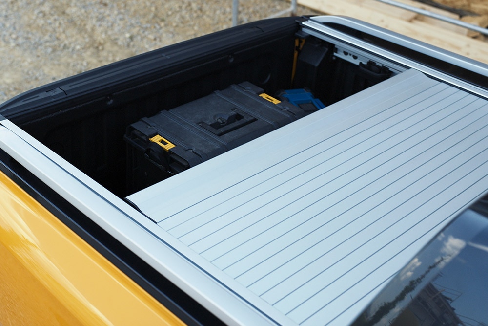 Arbeiter, der auf die integrierte hintere Stufe des Ford Ranger tritt.