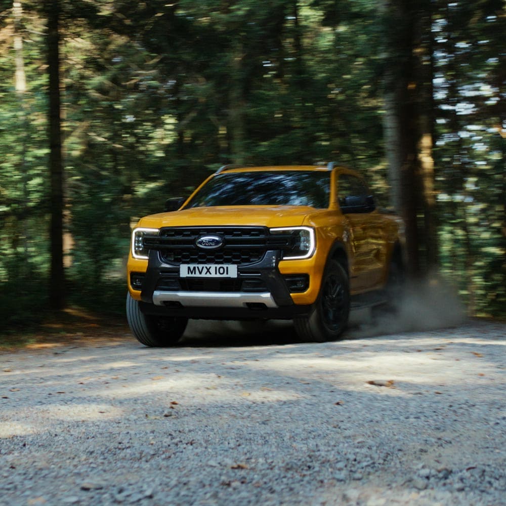 Video eines gelben Ford Ranger Wildtrak Doppelkabine, der auf Gebirgsstraßen und Schotterpisten unterwegs ist.