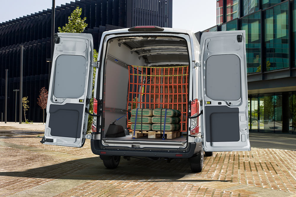 Ford Transit Kastenwagen mit geöffneten Hecktüren und Ladung im Laderaum.