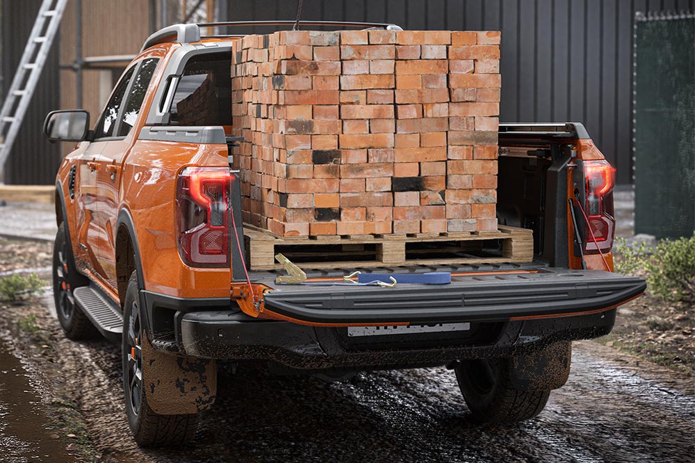 Heckansicht eines orangefarbenen Ford Ranger mit einem Stapel Ziegelsteine auf der Ladefläche.