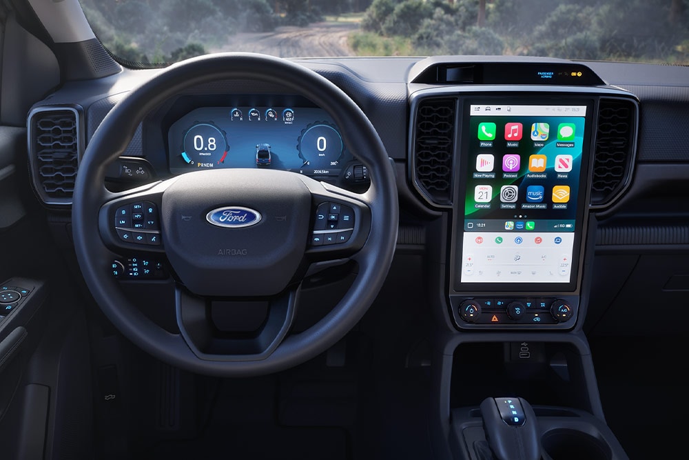 Innenansicht eines Ford Ranger mit Fokus auf Lenkrad, Armaturenbrett und Infotainment-Bildschirm.