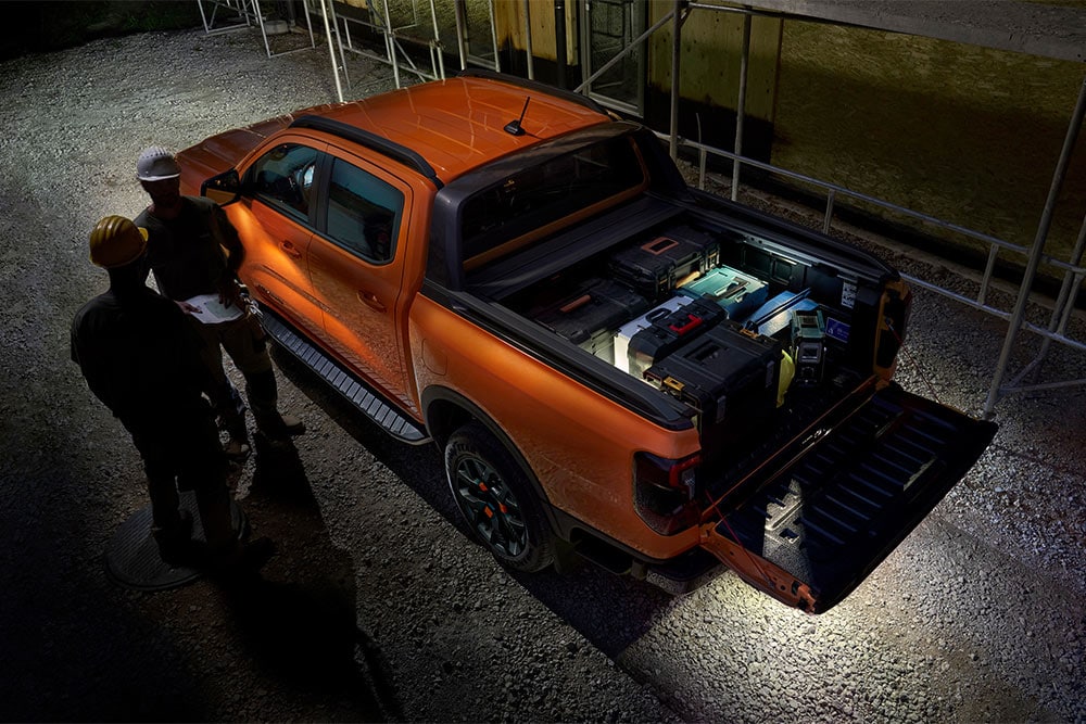 Draufsicht auf den orangefarbenen Ford Ranger Wildtrak bei Nacht mit Zonenbeleuchtung außen.