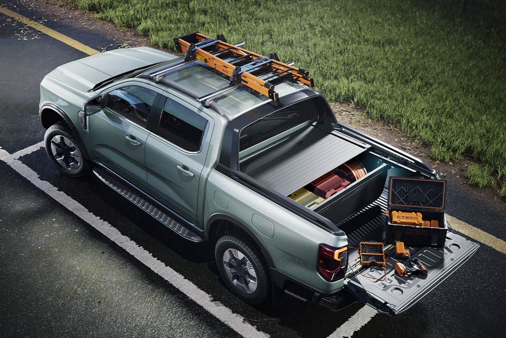 Ein gelber Ford Ranger fährt durch eine malerische Hügellandschaft.