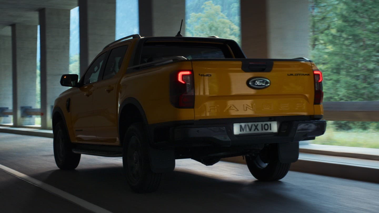 Ford Ranger Doppelkabine in Orange ¾-Heckansicht fährt durch Tunnelgalerie