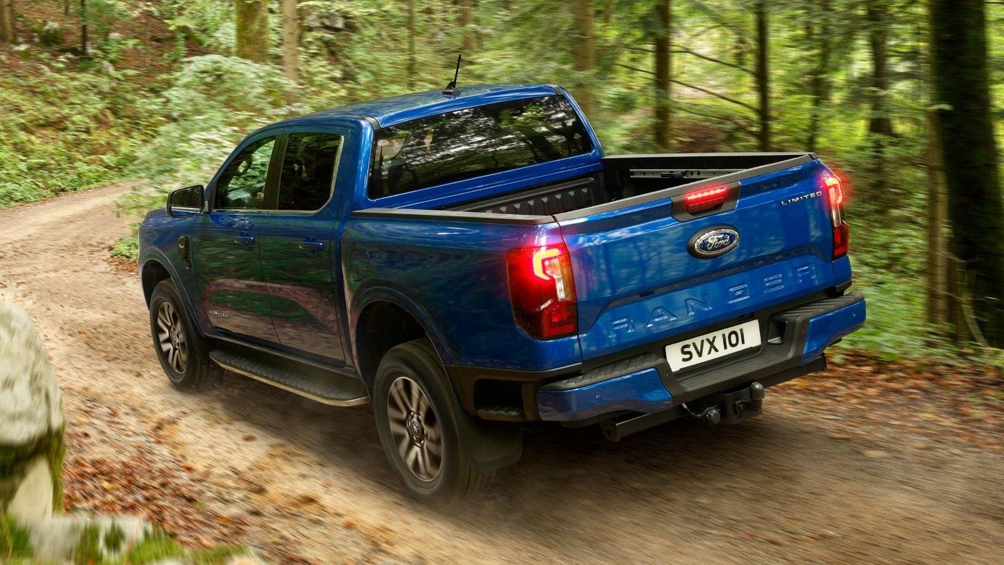 Ford Ranger in Blau in der ¾-Heckansicht fährt auf Waldweg