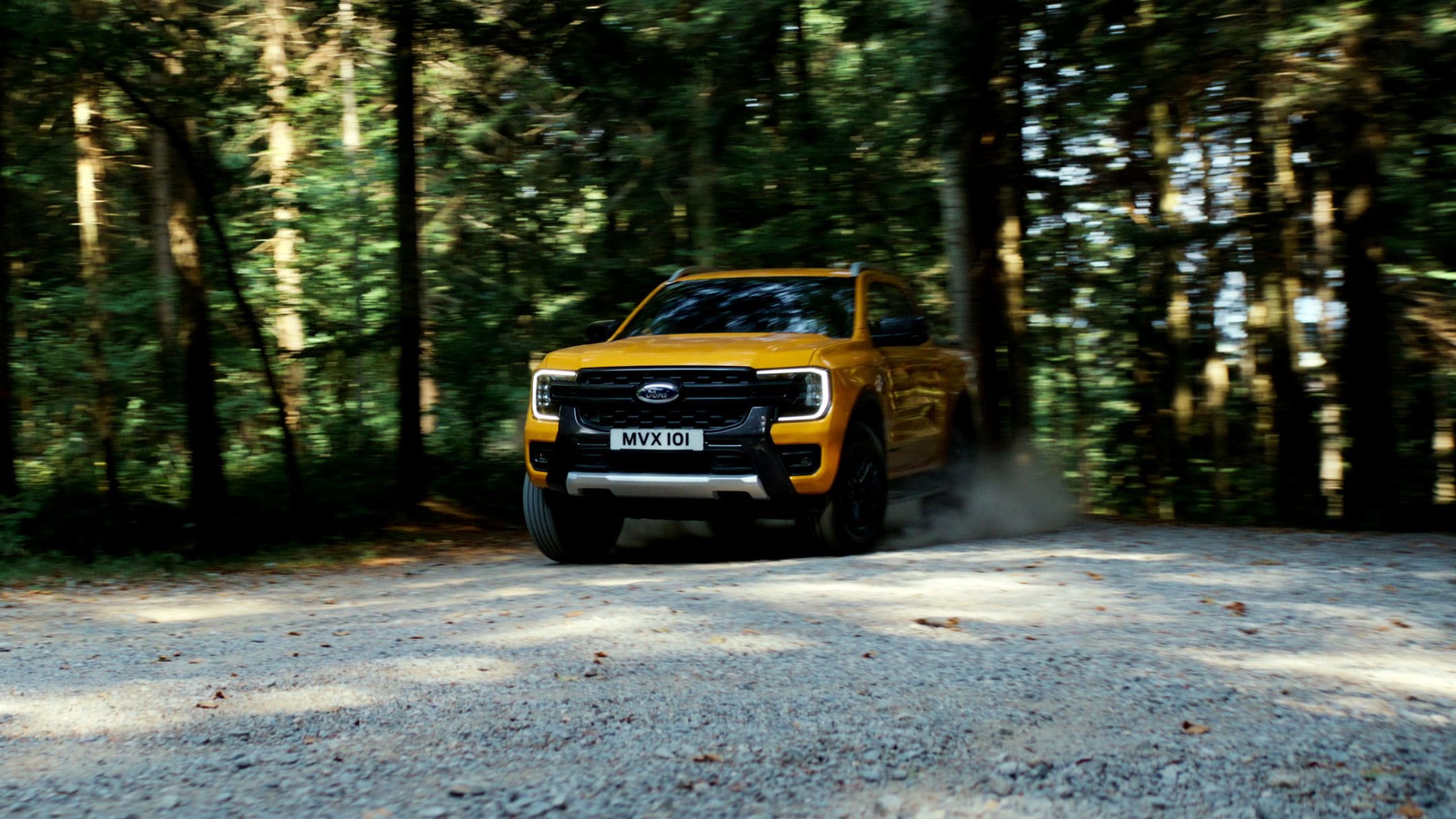 Ford Ranger in Orange Frontansicht fährt auf Waldweg