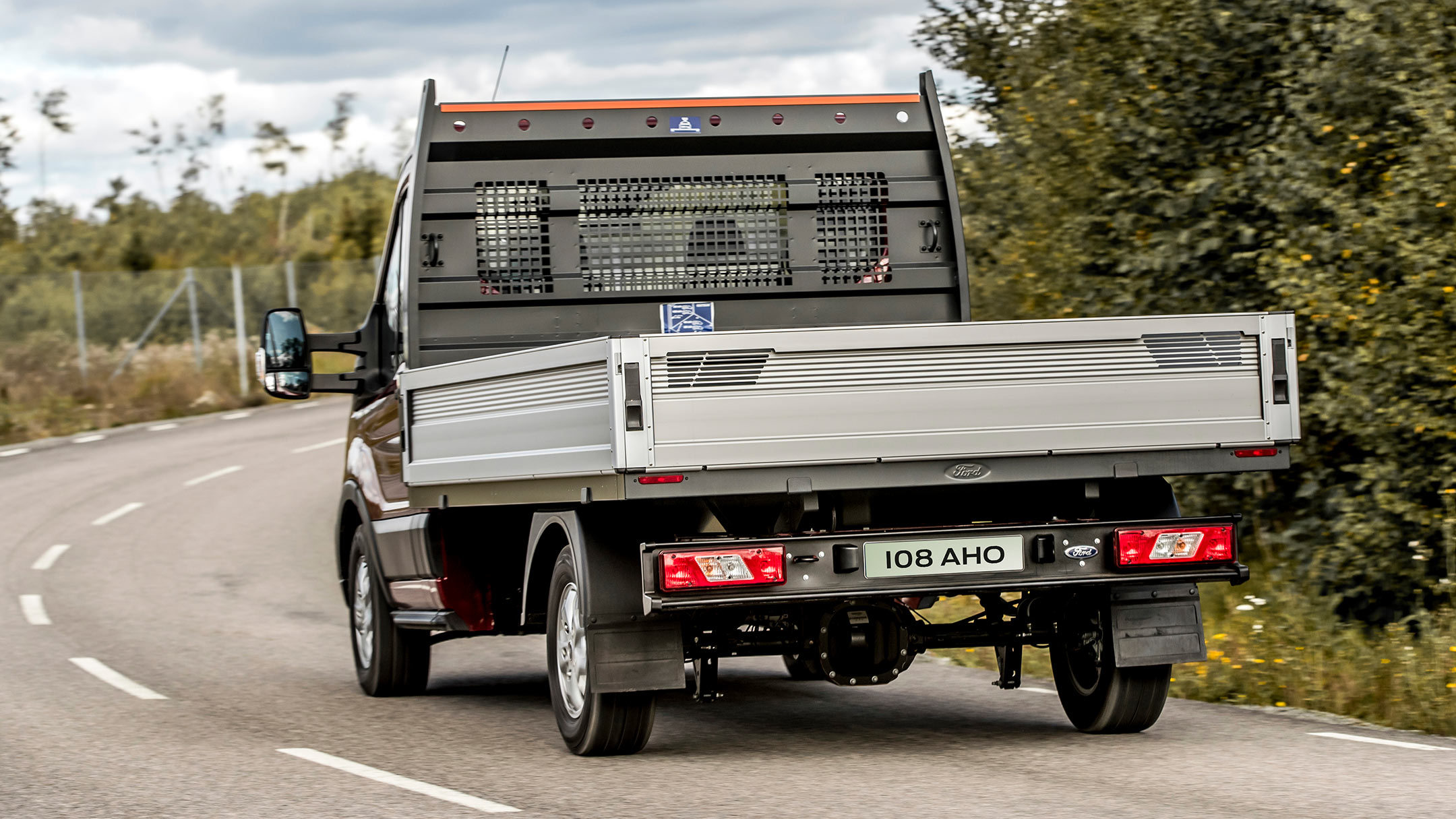 Ford Transit Pritschenwagen Einzelkabine Heckansicht Fahrszene auf Landstraße