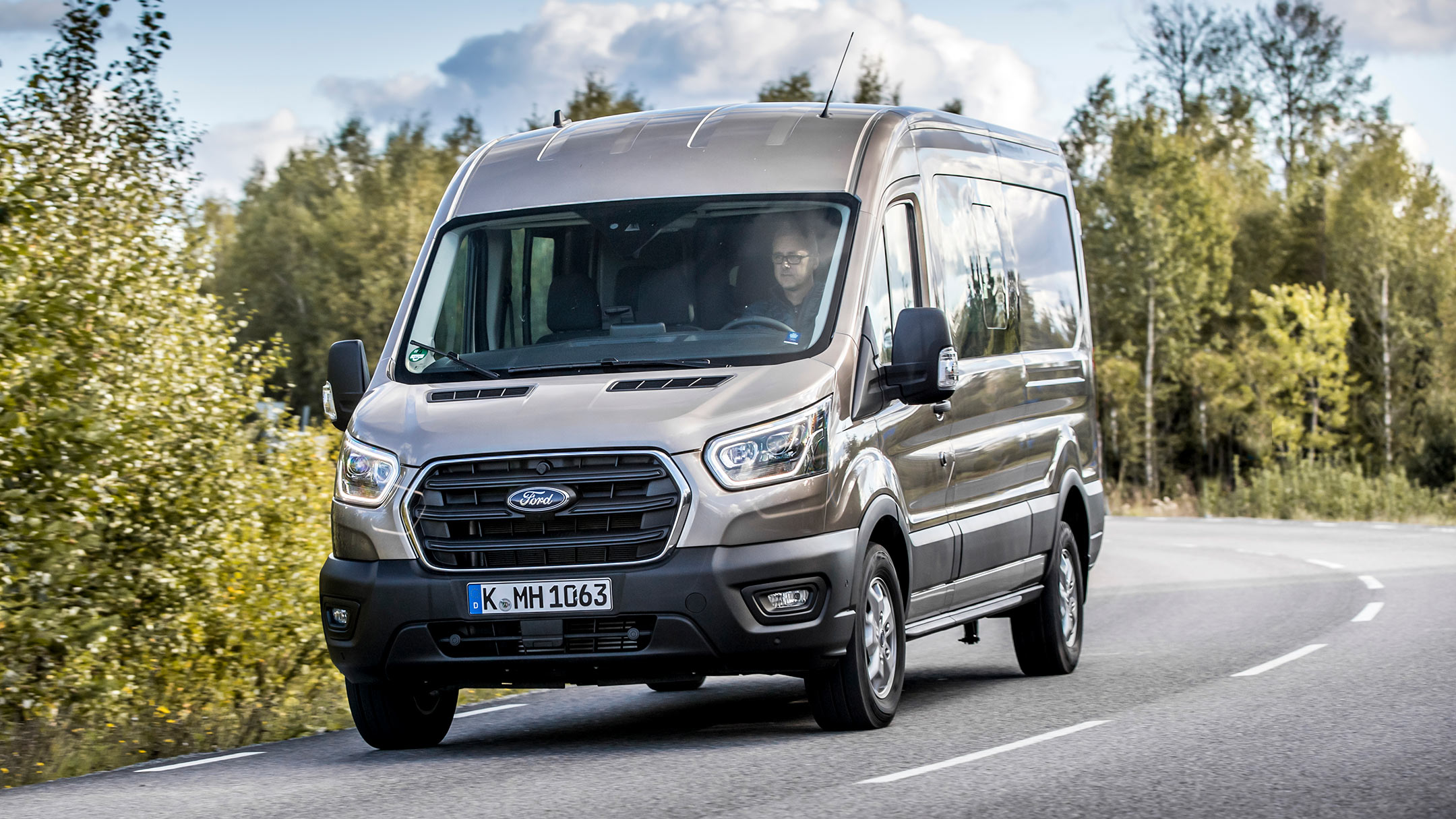 Ford Transit Doppelkabine LKW Champagner ¾-Frontansicht in Bewegung auf Landstraße